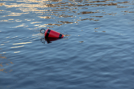 Single red mooring buoy on calm sea water.の写真素材