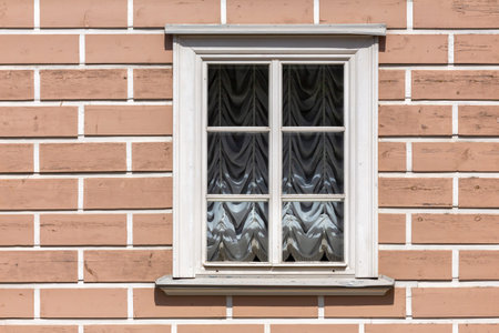 classic window in a white wooden frame with drapes in the Roman style. Curtains on the window. view from the streetの写真素材