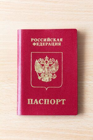 Russian passport on a light wooden background. The inscription in Russian: Russian Federation, Passport. An official document confirming the identity of a citizen for traveling abroadの写真素材