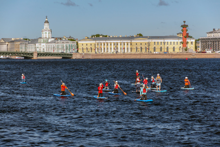 St. Petersburg, Russia - June 23, 2019: a group of people swims along the Neva River on the SUP boards in the early sunny morning. massive swim on the  boards. summer water activitiesのeditorial素材