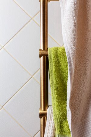 dryer with hanging soft towels in the tiled bathroomの写真素材