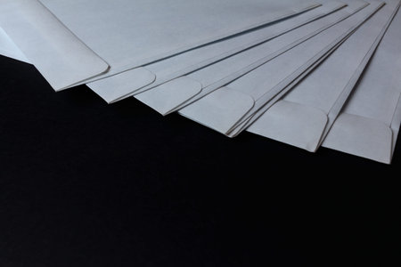 Blank white paper envelopes on a black background. concept of letters and postal messages