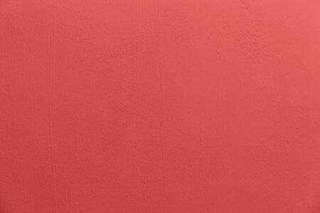 An empty clean concrete wall with an uneven texture is painted pink with brush marks. Used for web design and backgroundの写真素材