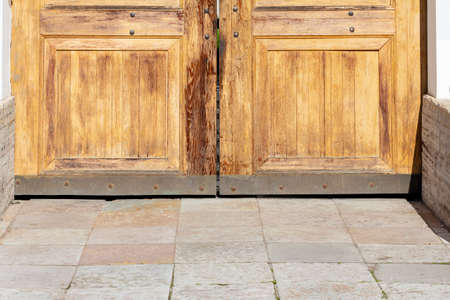 Closed massive old oak wood doors. Heavy wooden door with forged rivetsの写真素材