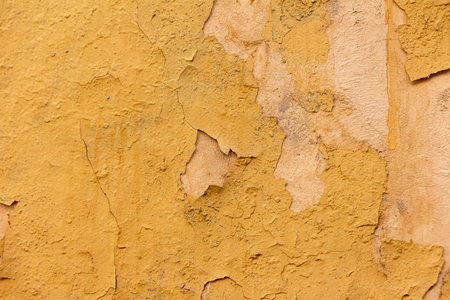 Texture of old plaster wall with peeling orange plaster