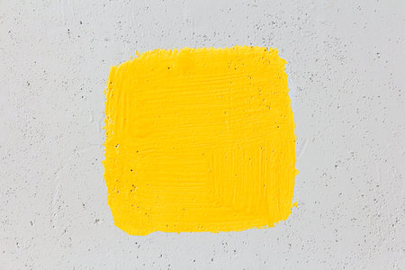 A square painted in bright yellow paint on a gray wall with place for text or image