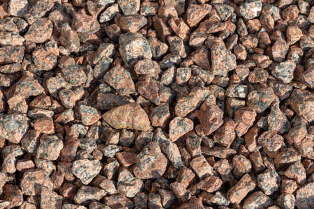 Crushed red granite stone for construction and landscaping. Mineral textureの写真素材