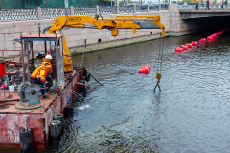 St. Petersburg, Russia - October 06, 2020: Cleaning the Karpovka River from mud and bottom silt using a submersible industrial pump from a floating stationのeditorial素材