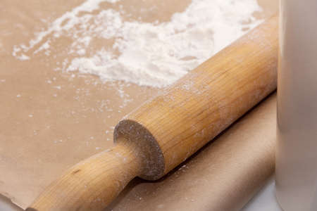 Rolling pin and sprinkled flour on baking parchment paper. Making a pie.の写真素材