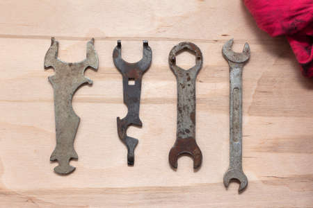 Old bike repair tools and dirty oiled red rag on wooden workbenchの写真素材