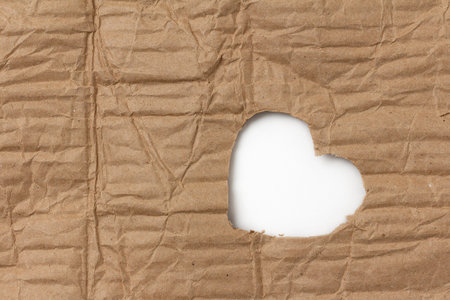 Cardboard heart from a crumpled box with a white background with space for textの写真素材