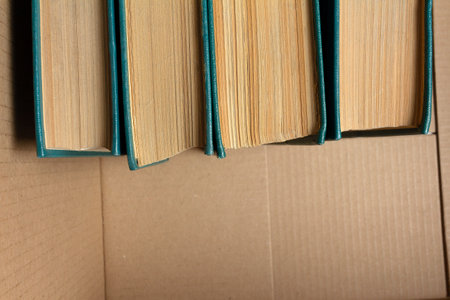 Old books with yellowed pages in a cardboard boxの写真素材
