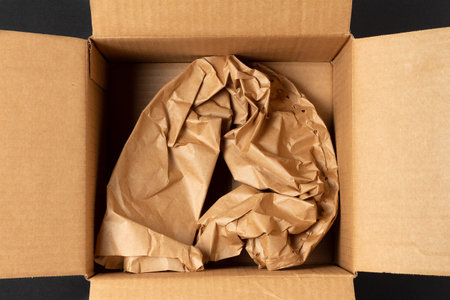 Crumpled brown wrapping paper in an open cardboard box