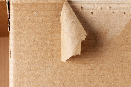 Scrap of torn cardboard on the damaged surface of a cardboard box. Cargo and shipments insurance conceptの写真素材