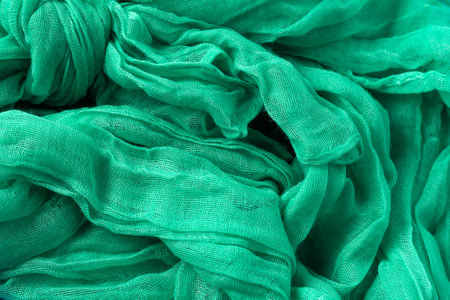 Classic green wavy delicate cotton scarf or shawl made of wrinkled fabric. Italian clothing styleの写真素材