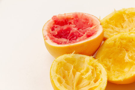 Squeezed oranges and grapefruit on a light background with space for text