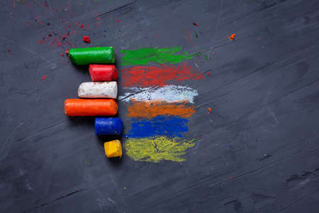 Multicolored striped shading with old colored wax crayons on dark backgroundの写真素材