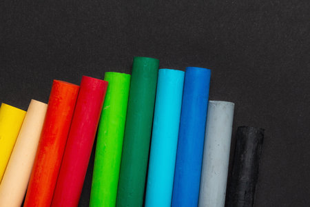 Oily wax pastel multicolored crayons on black paperの写真素材