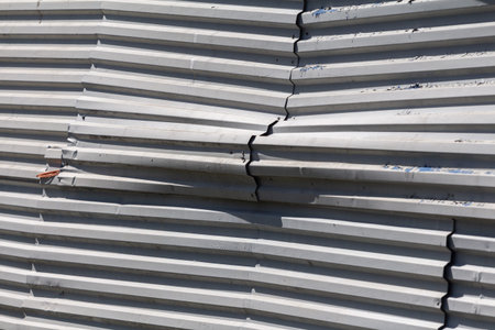 Damaged crumpled fence made of profiled metal sheets