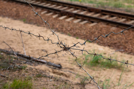 Rusty barbed wire on the background of the railway track