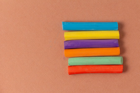 Colored pastel crayons on brown textured pastel paper