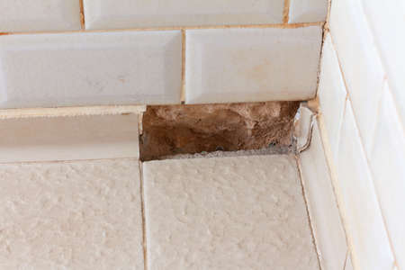 Wall in the shower room with broken tiles. Water destroy tiles and walls. bathroom renovationの写真素材
