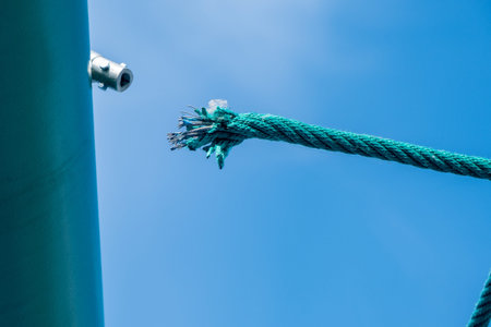 Damaged rope with sharp wire sticking out on the playground. Risk of injury during play