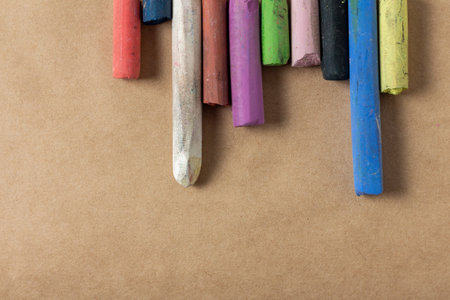 Row of colored pastel crayons for drawing on brown landscape paper. Dry pastel sticksの写真素材