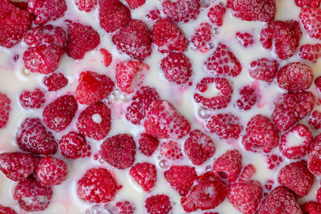 Ripe red raspberries in milk syrup for pie. Raspberry background textureの写真素材