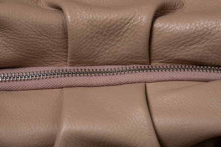 Women's brown purse with zipper close-up. Fragment of an elegant leather bag or wallet.の写真素材