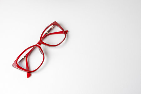 Modern women's glasses in red frames on a white background with copy space for advertising and textの写真素材