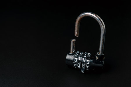 Broken padlock with a code and sawn shackle on a black backgroundの写真素材