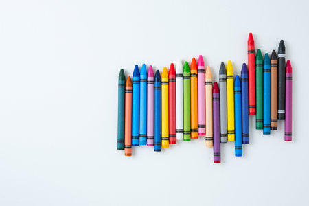 Large set of children's wax crayons on a white background. New colorful drawing crayons with space...