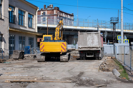 Dump truck and yellow excavator resting on a construction site during a break from work