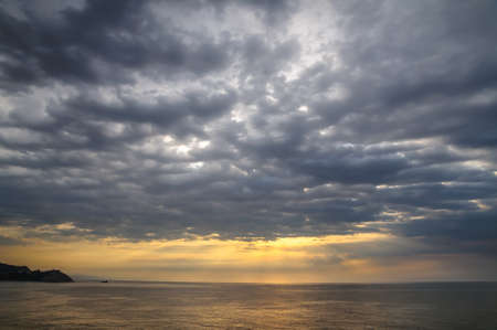 dramatic clouds over the sea at dawnの写真素材