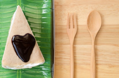 Crepe cake and heart shaped chocolate sauce, on banana leaf plate の写真素材
