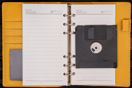 Notepad with black old floppy disk for computer