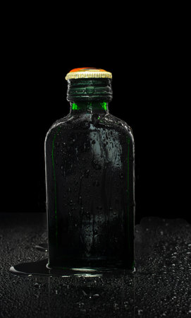 small green glass bottle on black backgroundの写真素材