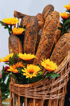 baguette of bread with flowers in a basketの写真素材