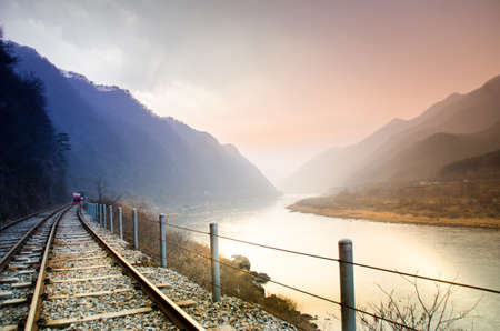 beautiful sunset scene with the river beside the railwayの写真素材