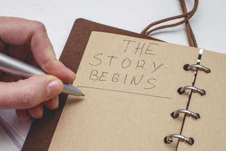 Diary with handwritten text The story begins. Concept of the beginning of a new story.の写真素材