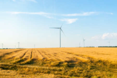 Blurred background: a group of windmills for generating electricity in a wheat field. No focusの写真素材