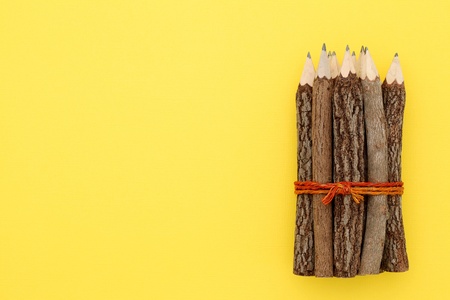 Wooden pencil on yellow paper background  の写真素材