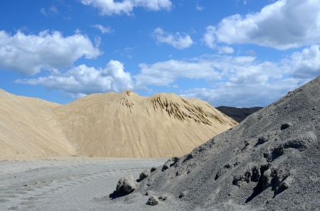 Gray and yellow gravel mound against skyの写真素材