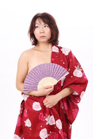 Portrait of naked woman in kimono with paper fanの写真素材