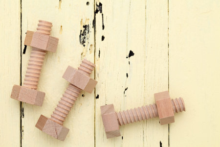 wooden bolts and nuts on wood backgroundの写真素材