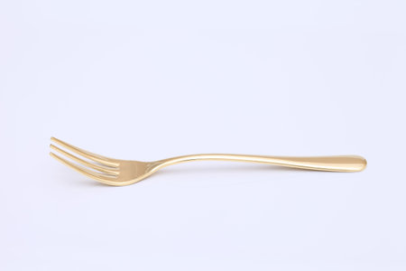 single golden fork on a gray background の写真素材