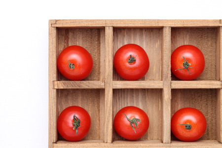 cherry tomatoes in wooden box isolated  on white の写真素材