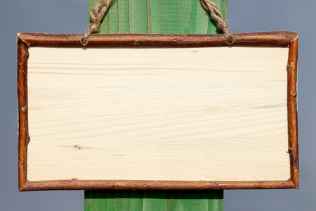 empty wooden sign hanging on a ropeの写真素材