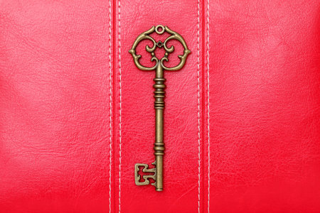 Vintage key on red leather backgroundの写真素材